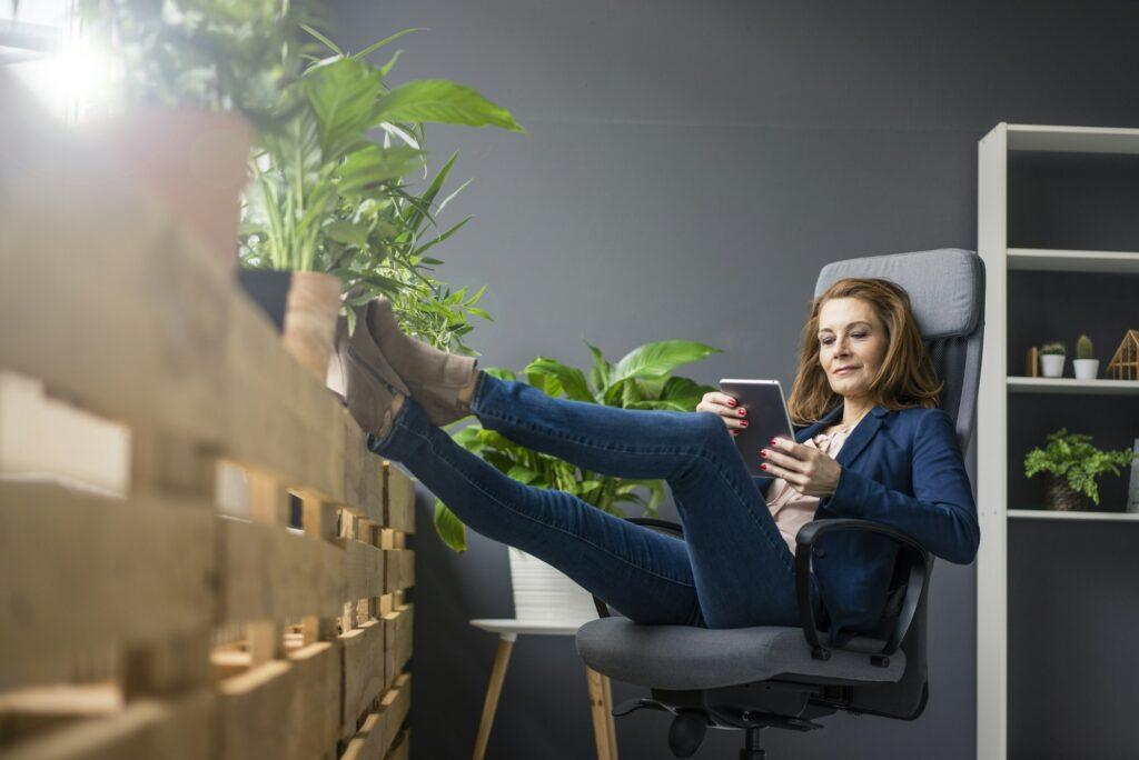 Mature businesswoman working in sustainable office, using digital tablet