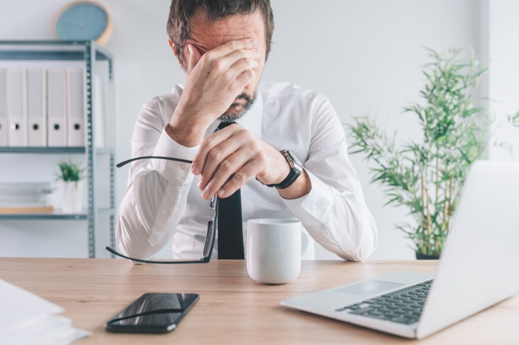 Businessman and entrepreneur realizing the big mistake he made, hand covering face in disbelief